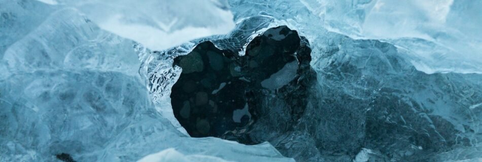 A hole in an ice sheet covering dark blue water